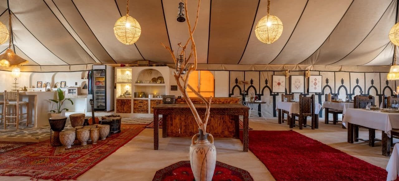 Reception lounge with Berber drums and bar at Dihya luxury desert camp Morocco